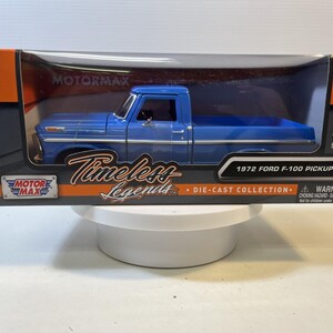 May include: A blue 1972 Ford F-100 pickup truck die-cast model in its original box. The box features the "MOTORMAX" and "Timeless Legends" logos, and the model is a 1:24 scale. The box also has a warning label and a 3+ age recommendation.
