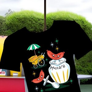 May include: Black t-shirt with a retro illustration of a hot dog cart, a smiling hot dog, and a jar of mustard. The hot dog is wearing a red and white hat and the mustard jar has a yellow lid and the word "Mustard" written on it.