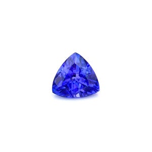 Puede incluir: Una vibrante gema azul, tallada en forma triangular. La gema tiene una superficie facetada que refleja la luz, creando una brillante exhibición de color. La gema se encuentra sobre un fondo blanco liso.