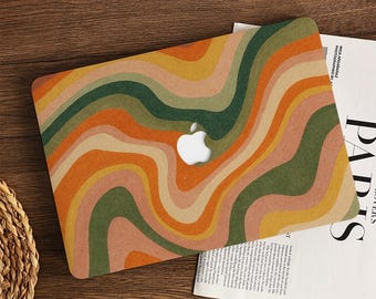 May include: A laptop case with a retro wavy pattern in shades of orange, green, yellow, and beige. The case has a cutout for the Apple logo. The design is reminiscent of the 1970s. The case is made of a durable material.