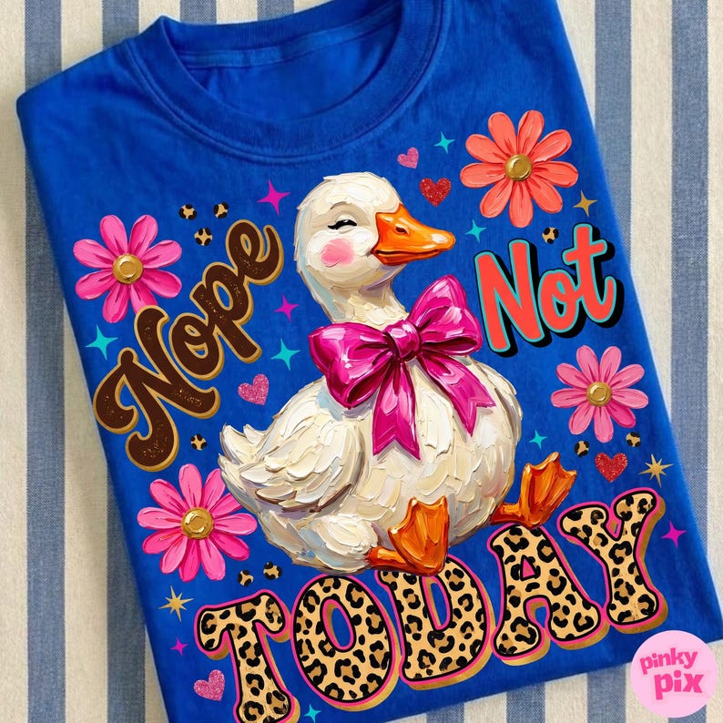 May include: A blue t-shirt featuring a white duck with a pink bow, orange beak and feet, and rosy cheeks. The shirt has the words "Nope Not Today" in a mix of fonts and colors, with floral and heart accents.