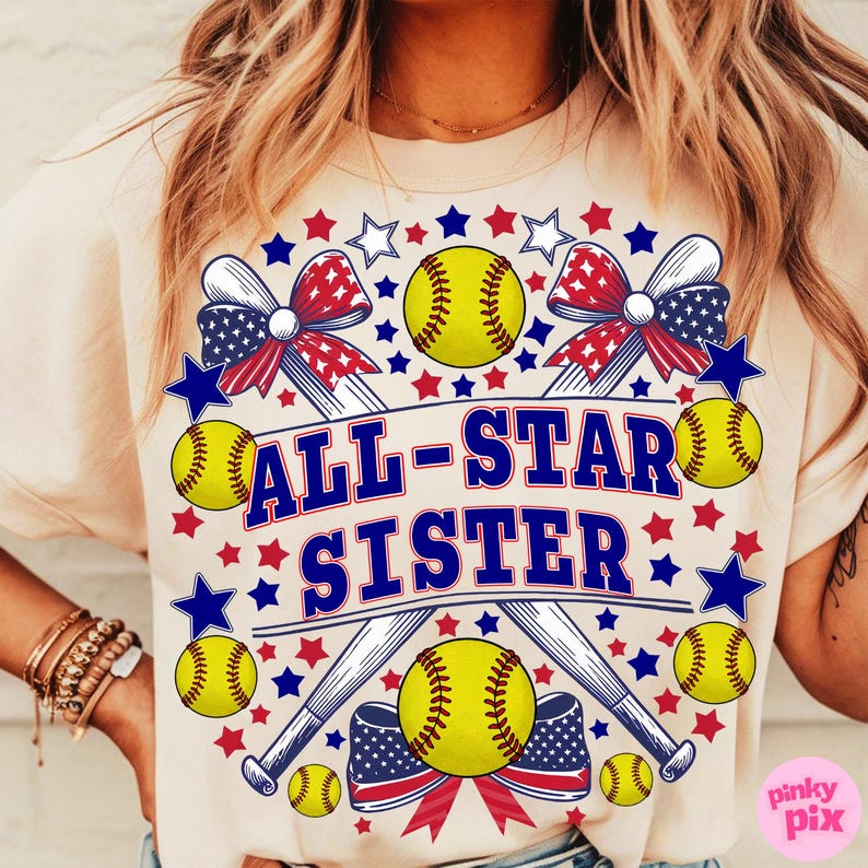 May include: Cream-colored t-shirt featuring a softball-themed design. The design includes yellow softballs, crossed baseball bats, and the text "ALL-STAR SISTER" in blue. Red, white, and blue stars and bows complete the patriotic theme.