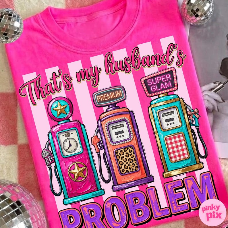 May include: A bright pink t-shirt with the phrase "That's my husband's PROBLEM" and illustrations of three vintage gas pumps. The gas pumps are in shades of pink, orange, and teal.