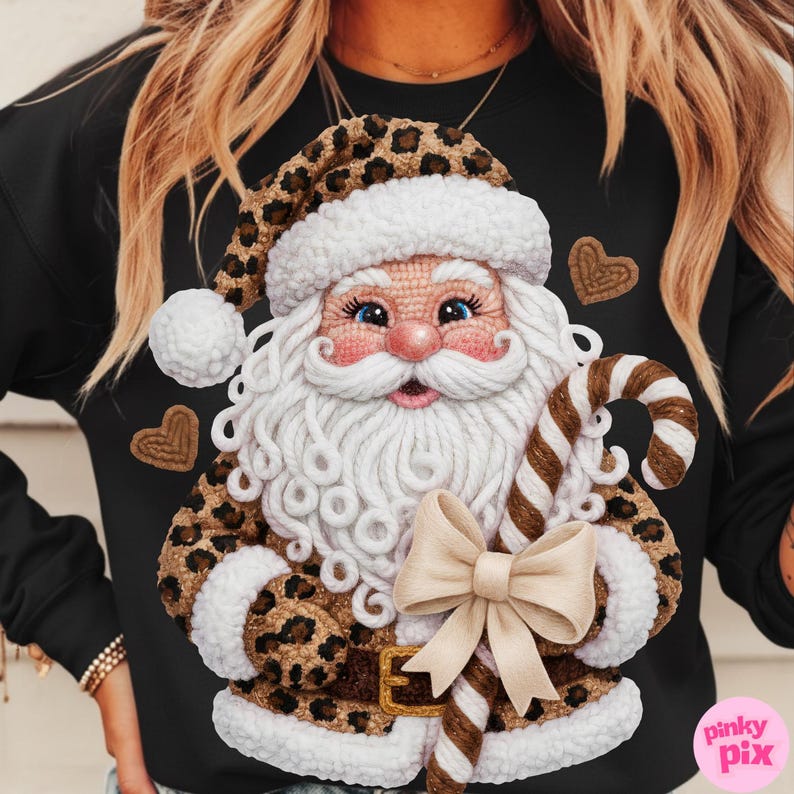 May include: Black sweatshirt featuring a Santa Claus design with a leopard print hat and coat. Santa holds a candy cane and has a white beard and mustache. A beige bow is at the bottom of the design. Two brown heart shapes are on the sweatshirt.