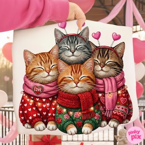 May include: A white pillow featuring a group of four smiling cartoon cats. The cats wear sweaters and scarves, with heart-shaped headbands. The sweaters are red and green, decorated with hearts and roses. The scarves are pink and red.