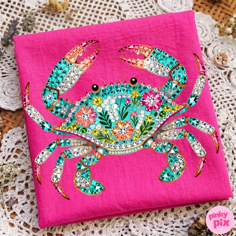 May include: A hot pink fabric features a detailed crab design. The crab is adorned with turquoise, orange, and clear crystal-like embellishments. Floral patterns and sparkling accents decorate the crab's body and claws, creating a vibrant and eye-catching design.