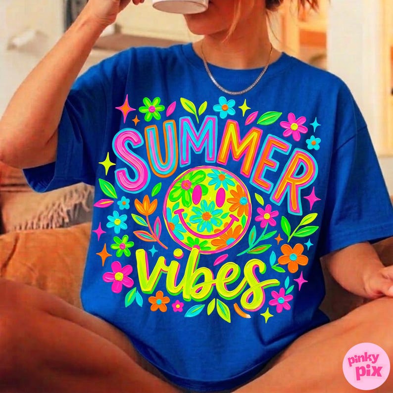 May include: A royal blue t-shirt with a vibrant graphic design. The design features the words "SUMMER VIBES" in a colorful, playful font, along with a smiley face and floral accents. The shirt is a casual, relaxed fit.
