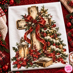 May include: A white fabric featuring a printed graphic of a rustic wooden cross adorned with a large red ribbon, pine cones, and holly. A lit lantern, a stack of books, and poinsettia flowers sit at the base, next to a snow-dusted evergreen tree.