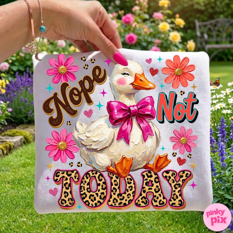 May include: White square pillow with a cartoon duck wearing a pink bow. The pillow has the words "Nope Not Today" in various fonts and colors, along with pink flowers and hearts. The duck has rosy cheeks and orange feet.