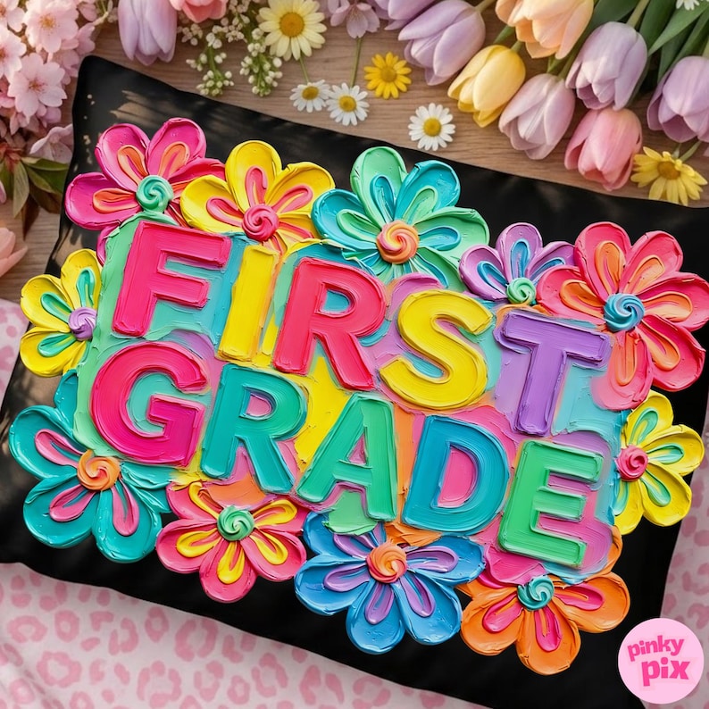 May include: A black pillow decorated with colorful, textured flowers and the words "FIRST GRADE" in bright, bold letters. The flowers are in shades of pink, yellow, blue, and orange, creating a vibrant, cheerful design.