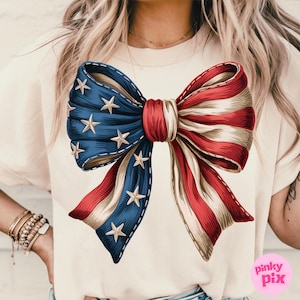 May include: A white t-shirt with a large red, white, and blue bow printed on the front. The bow is designed to look like an American flag.