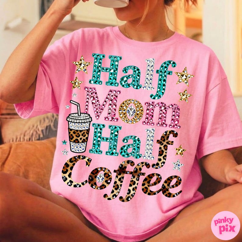 Może przedstawiać: R&oacute;żowa koszulka z napisem "Half Mom Half Coffee" w kolorze turkusowym, r&oacute;żowym i w panterkę. Projekt zawiera grafikę filiżanki kawy i akcenty gwiazd. Koszulka jest w stylu casual i oversize.