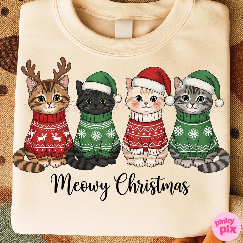 以下が含まれることがあります： クリスマスセーターと帽子をかぶった4匹の漫画の猫が描かれたクリーム色のスウェットシャツ。猫は、お祝いの模様が入った赤と緑のセーターを着ています。下のテキストは「Meowy Christmas」と書かれています。
