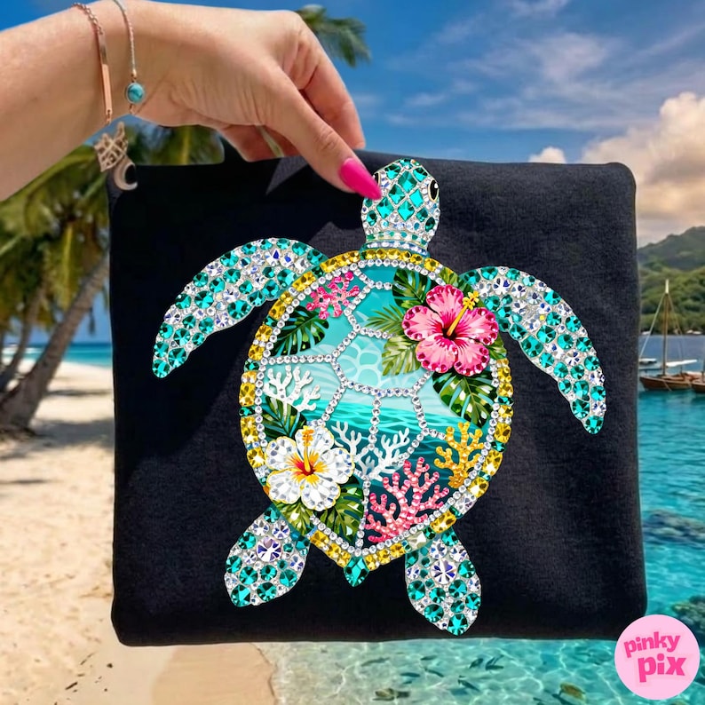 May include: Black tote bag featuring a bejeweled sea turtle design. The turtle has turquoise, yellow, and clear crystal accents, with a tropical scene inside the shell. Pink and white hibiscus flowers and coral complete the design.