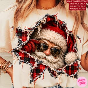 May include: A beige t-shirt featuring a graphic of Santa Claus wearing gold-rimmed aviator sunglasses and a red plaid hat. The design has a distressed, torn-paper effect with frayed edges, revealing the face and beard of Santa Claus.