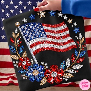 May include: Black tote bag featuring a sparkling American flag design. The flag is embellished with red, white, and blue rhinestones. The design includes a wreath of flowers and stars, creating a patriotic theme.