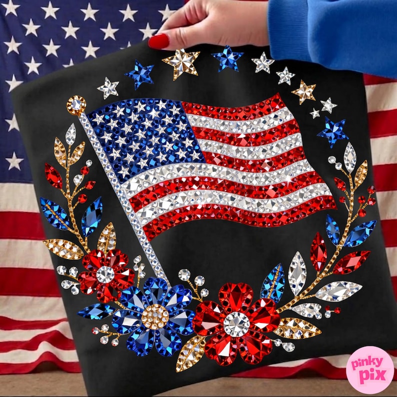 May include: Black tote bag featuring a sparkling American flag design. The flag is embellished with red, white, and blue rhinestones. The design includes a wreath of flowers and stars, creating a patriotic theme.