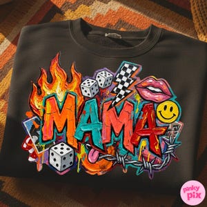 May include: Dark gray sweatshirt with a colorful graphic design. The design features the word "MAMA" in graffiti style, flames, dice, a lightning bolt, lips, a smiley face, and barbed wire.