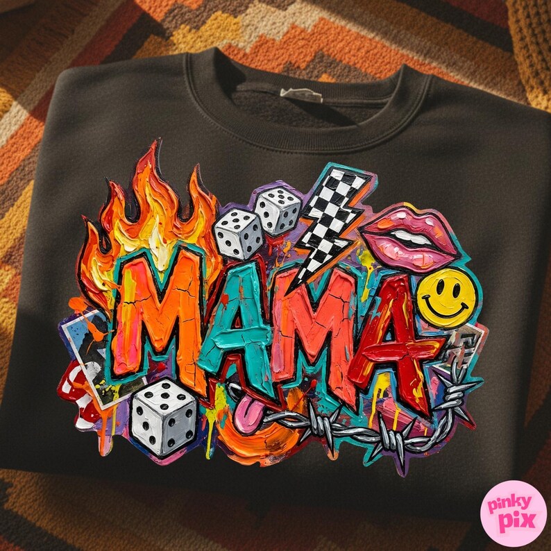 May include: Dark gray sweatshirt with a colorful graphic design. The design features the word "MAMA" in graffiti style, flames, dice, a lightning bolt, lips, a smiley face, and barbed wire.