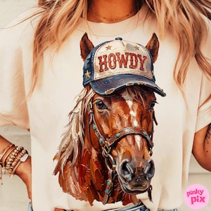 May include: A beige t-shirt featuring a detailed illustration of a brown horse wearing a blue and white baseball cap with the word "HOWDY" on it. The horse has a bridle with turquoise accents.