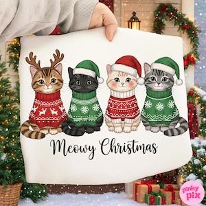 Könnte beinhalten: Ein weißes rechteckiges Kissen mit vier Cartoon-Katzen, die Weihnachtspullover und -mützen tragen. Die Katzen tragen rote und grüne Pullover mit dem Text "Meowy Christmas" darunter. Die Katzen sind braun, schwarz und grau.