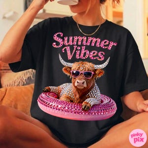May include: Black t-shirt with the text "Summer Vibes" in pink rhinestone lettering. The shirt features a brown Highland cow wearing sunglasses and a rhinestone-studded floatie. The cow is also adorned with rhinestones.