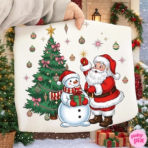May include: A Christmas-themed pillow featuring Santa Claus, a snowman, and a decorated Christmas tree. Santa is holding a star, and the snowman is holding a gift. The tree is adorned with ornaments and pink bows.