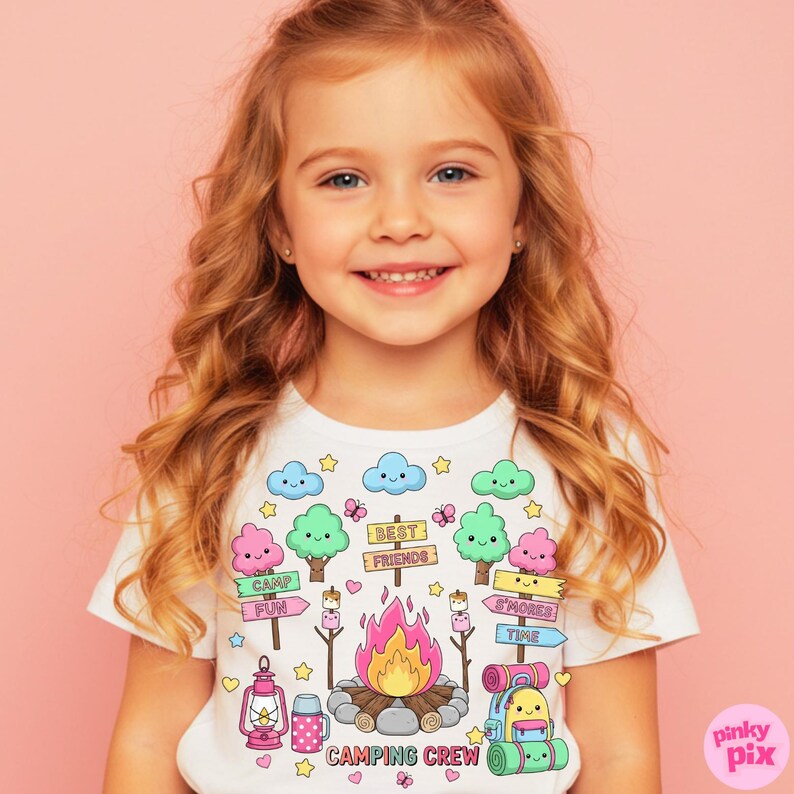 May include: White t-shirt with a colorful camping-themed graphic. The design includes a campfire, trees, clouds, and the words "Camping Crew." The shirt features a cute, cartoonish style with pastel colors and is suitable for children.