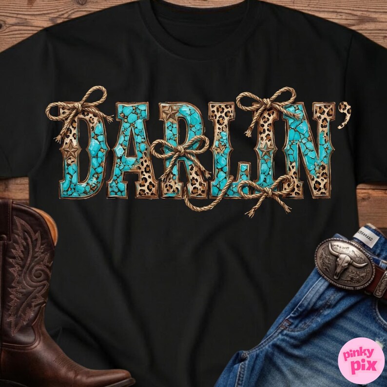 Pu&ograve; includere: T-shirt nera con la scritta "DARLIN" in turchese, stampa leopardata e dettagli in corda. Le lettere hanno un aspetto turchese simile a una pietra, con stampa leopardata e dettagli a stella. Fiocchi di corda sono legati attorno alle lettere.