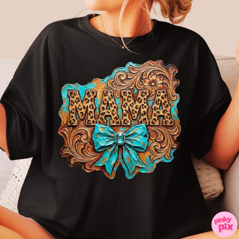 May include: Black t-shirt featuring a decorative design with the word "MAMA" in leopard print. The design includes a turquoise bow and a brown, gold, and turquoise floral pattern.