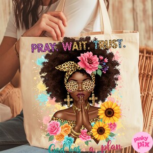 May include: A tote bag with a colorful design featuring a woman with a leopard print headband and sunglasses, praying with her hands clasped. The text "Pray. Wait. Trust. God has a plan" is printed on the bag.