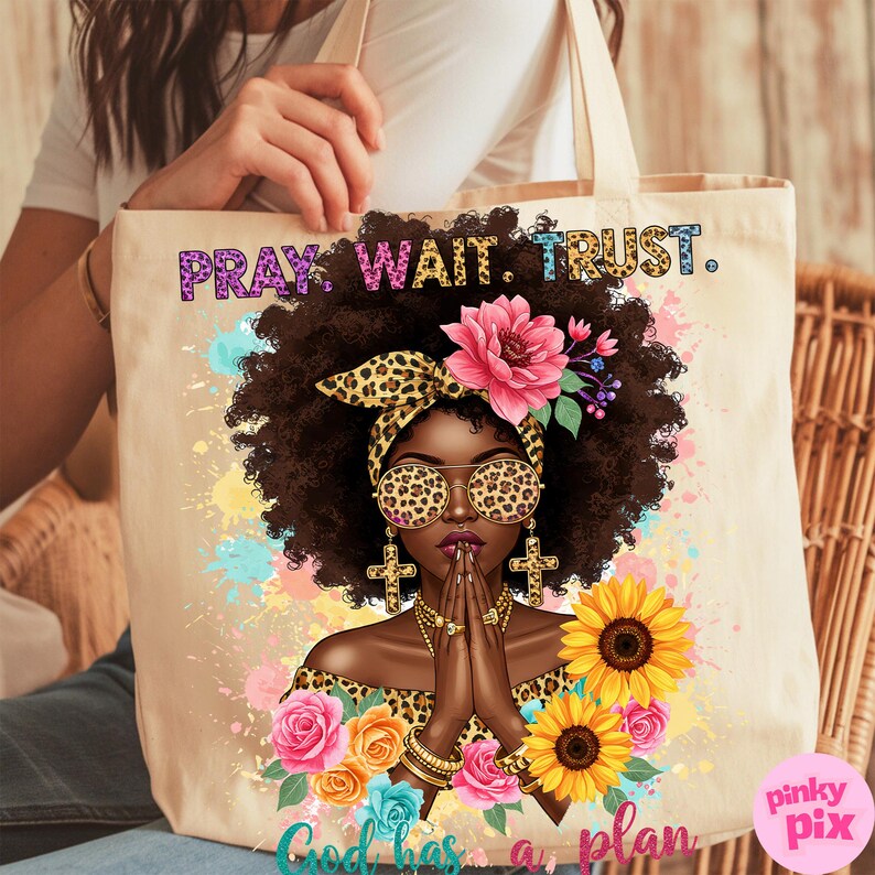 May include: A tote bag with a colorful design featuring a woman with a leopard print headband and sunglasses, praying with her hands clasped. The text "Pray. Wait. Trust. God has a plan" is printed on the bag.