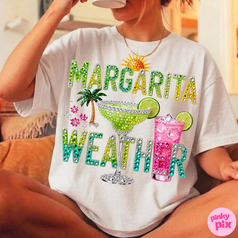 Peut inclure: T-shirt blanc avec l'inscription "MARGARITA WEATHER" en lettres orn&eacute;es de bijoux. Le motif comprend un verre &agrave; margarita, un cocktail rose, un palmier et un soleil.