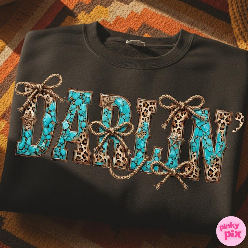 Pu&ograve; includere: Felpa nera con la scritta "DARLIN'" in turchese, stampa leopardata e dettagli in corda. Le lettere sono riempite di pietre turchesi e incorniciate da stampa leopardata. Fiocchi e stelle di corda aggiungono dettagli.