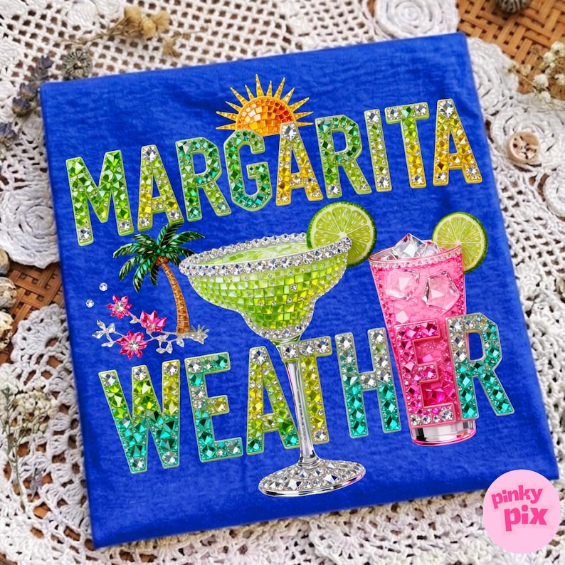 Peut inclure: T-shirt bleu avec l'inscription &laquo; Margarita Weather &raquo; en lettres serties de bijoux. Le motif comprend un verre &agrave; margarita orn&eacute; de bijoux, un cocktail rose, un soleil, un palmier et des tranches de citron vert.
