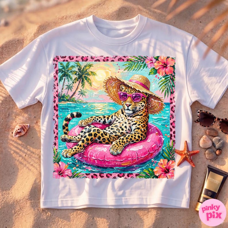 May include: White t-shirt with a leopard wearing sunglasses and a straw hat, relaxing on a pink inflatable ring in the sea. The design includes palm trees, flowers, and a pink leopard print border.