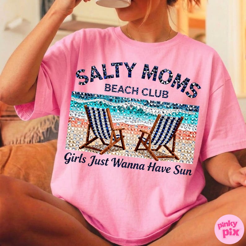 May include: Pink t-shirt with the text "Salty Moms Beach Club" above a beach scene with two chairs. Below the beach scene is the text "Girls Just Wanna Have Sun".