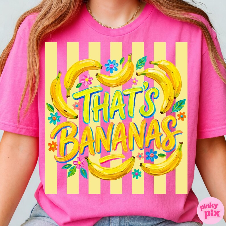 Pu&ograve; includere: T-shirt rosa con sfondo a righe gialle e bianche. La maglietta presenta la frase "THAT'S BANANAS" in un carattere giocoso, circondata da banane gialle e fiori colorati. Un design divertente e vivace.