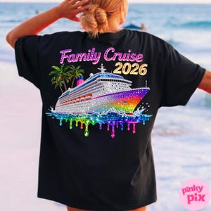 Op de afbeelding: Zwart T-shirt met een kleurrijke afbeelding van een cruiseschip met de tekst "Family Cruise 2026". Het schip is versierd met regenboogkleurige edelstenen en staat tegen een tropische achtergrond met palmbomen.