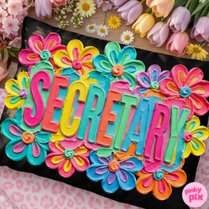 May include: A black pillow decorated with colorful, textured flowers and the word "SECRETARY" in vibrant, multi-colored letters. The flowers are in shades of pink, yellow, blue, and orange, creating a cheerful and artistic design.