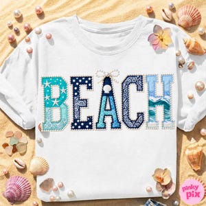 May include: White t-shirt with the word "BEACH" in blue, turquoise, and white patterned letters. The letter designs include stars, polka dots, paisley, and wave patterns. A small bow and seashell accent the letter "A". Seashells and pearls surround the shirt.