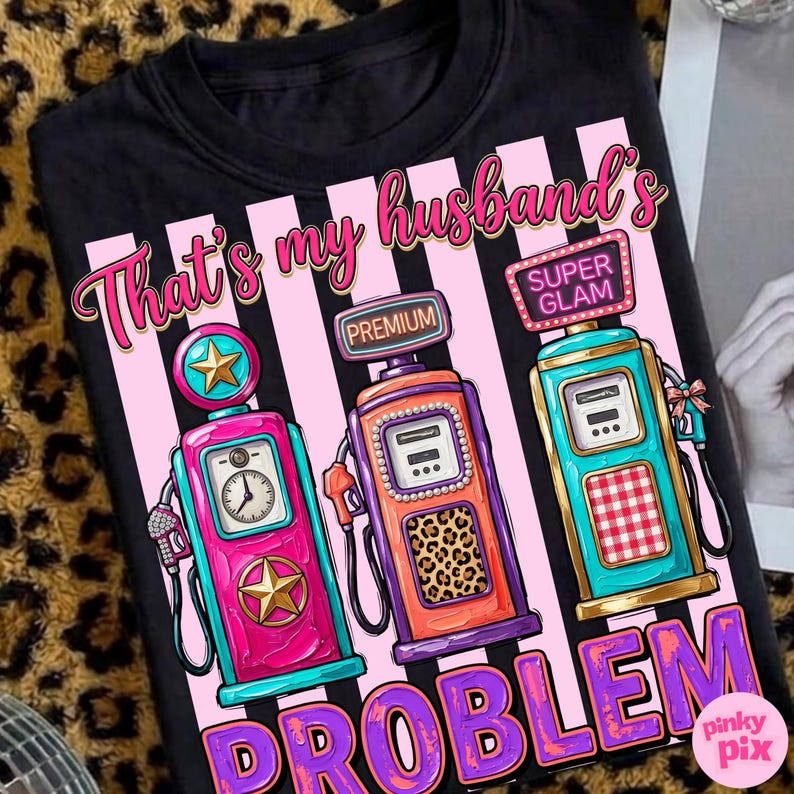 May include: Black t-shirt with a graphic of three vintage gas pumps in pink, teal, and orange, with the text "That's my husband's problem" in pink and purple. The pumps have star and leopard print details.
