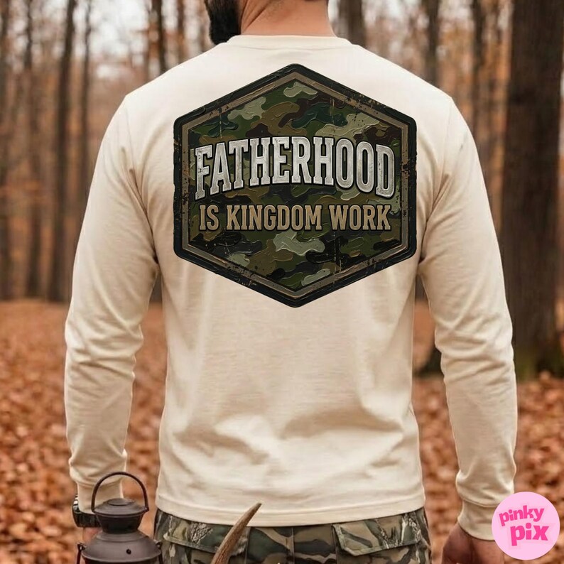 Pode incluir: Camiseta de manga comprida creme com um grande patch hexagonal nas costas. O patch apresenta um padr&atilde;o de camuflagem e o texto "FATHERHOOD IS KINGDOM WORK" em uma fonte desgastada. A camisa &eacute; feita de um material macio.