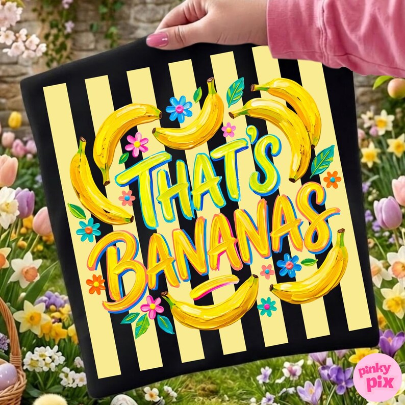 Pu&ograve; includere: Cuscino decorativo a righe nere e gialle con la scritta "That's Bananas" in lettere colorate. Il cuscino presenta illustrazioni di banane gialle, fiori blu e rosa e foglie verdi.