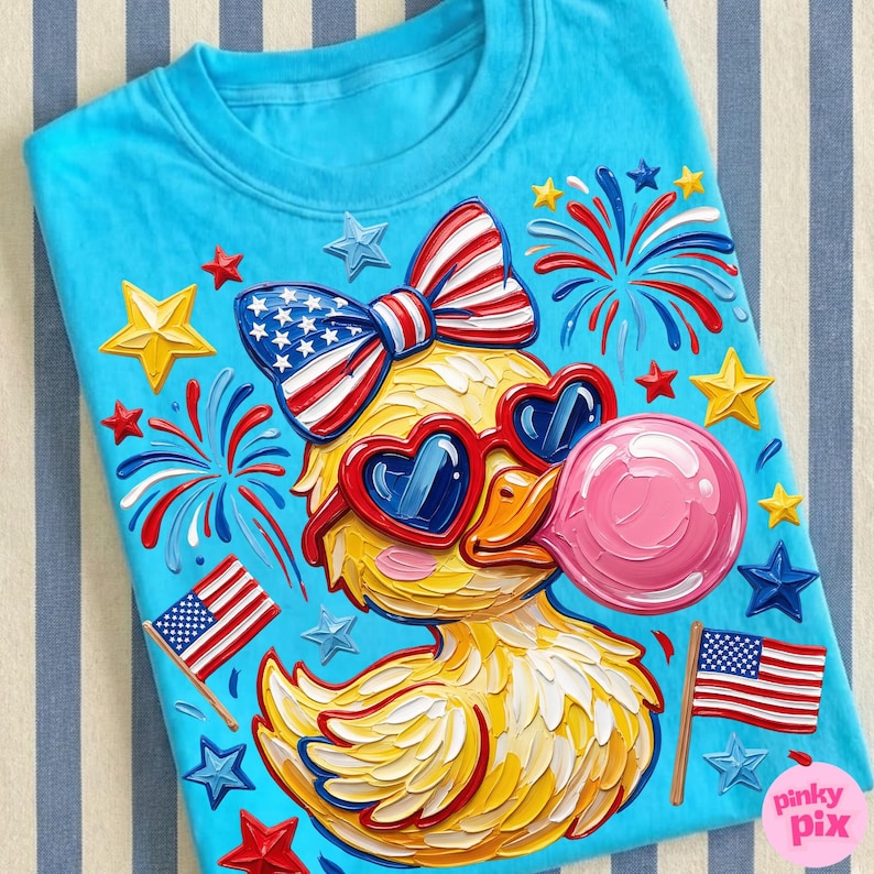 May include: A light blue t-shirt featuring a cartoon duck wearing heart-shaped sunglasses and blowing a pink bubble. The duck is decorated with a patriotic bow, American flags, fireworks, and stars. The shirt is decorated with red, white, blue, and yellow accents.