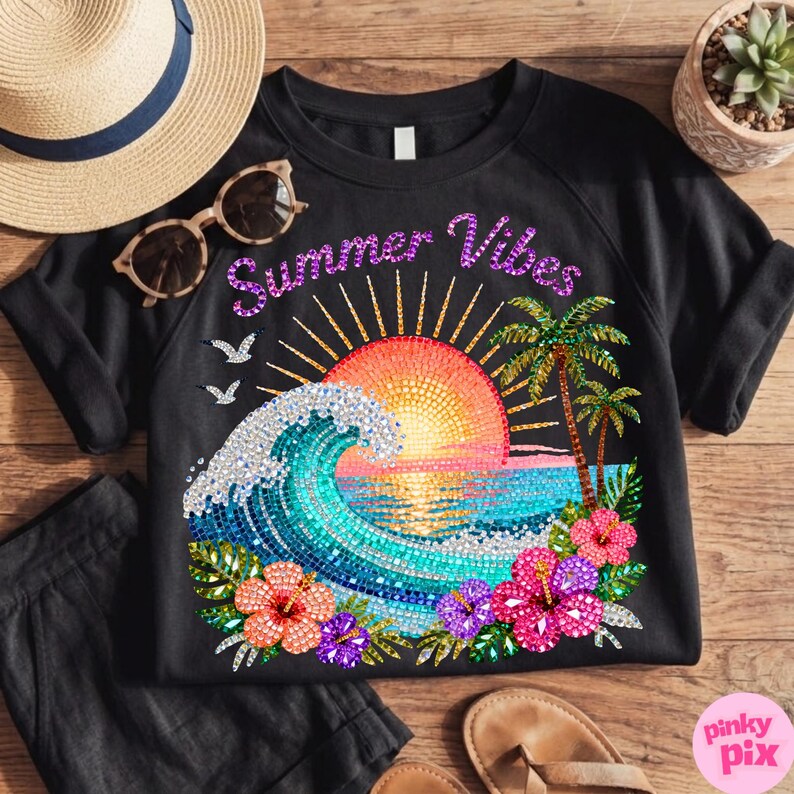 May include: Black sweatshirt with a colorful graphic of a sunset over the ocean, palm trees, and flowers. The words "Summer Vibes" are written across the top. A straw hat and sunglasses are next to the shirt.
