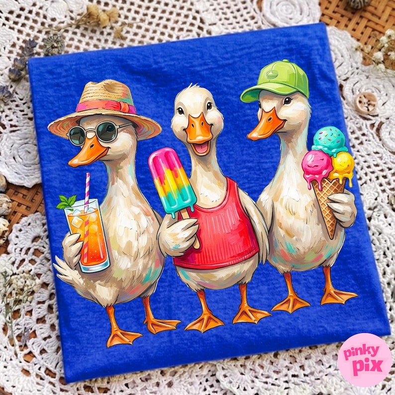 May include: A blue t-shirt featuring three cartoon ducks enjoying summer treats. One duck wears a straw hat and sunglasses, holding a cocktail. Another has a popsicle, and the third holds an ice cream cone. The ducks are on a blue background.