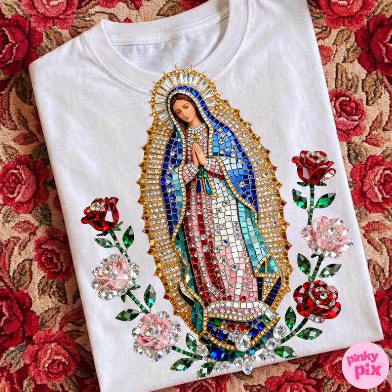 May include: White t-shirt featuring a detailed, jeweled depiction of the Virgin Mary. The design includes blue, pink, and gold accents, surrounded by jeweled roses in red and pink. The shirt has a crew neck.