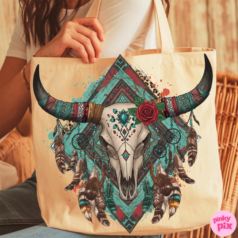 May include: Cream-coloured tote bag with a detailed illustration of a bull skull with long black horns. The design includes turquoise, red, and brown accents, a red rose, and hanging feathers, evoking a bohemian or Southwestern theme.