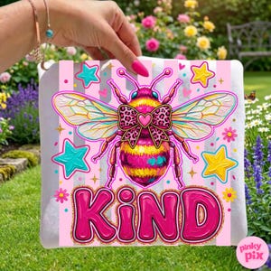May include: A pink and white striped square with a large, colorful bee illustration. The bee has a leopard print bow and heart. The word "KIND" is written in large, pink, bubble letters with a gold outline. Turquoise and yellow stars are scattered around the bee.